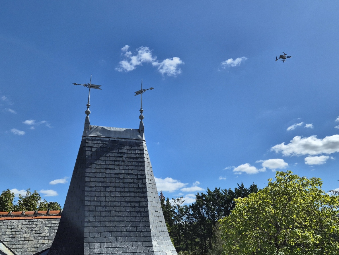 Drone réalisant l'inspection d'une toiture pour un rapport détaillé